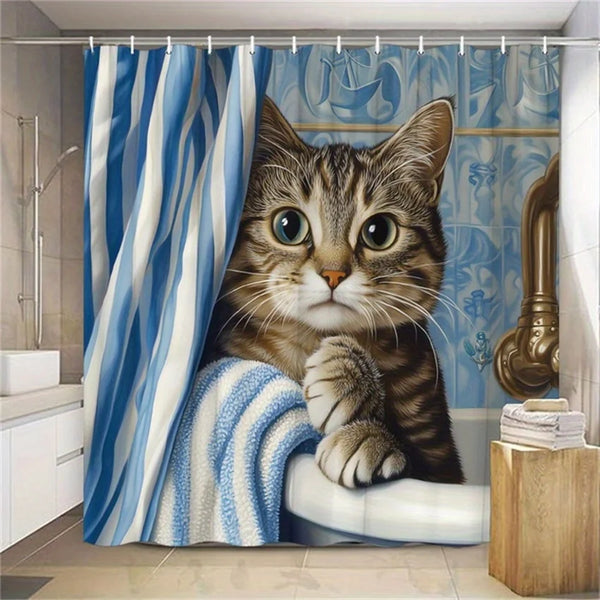 A tabby kitten is resting on a blue and white striped shower curtain, looking directly at the camera.