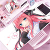 Anime girl illustration on a pink mouse pad featuring pink hair and blue eyes
