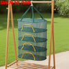 A folding wooden rack holds a green mesh drying net with yellow handles for hanging items.