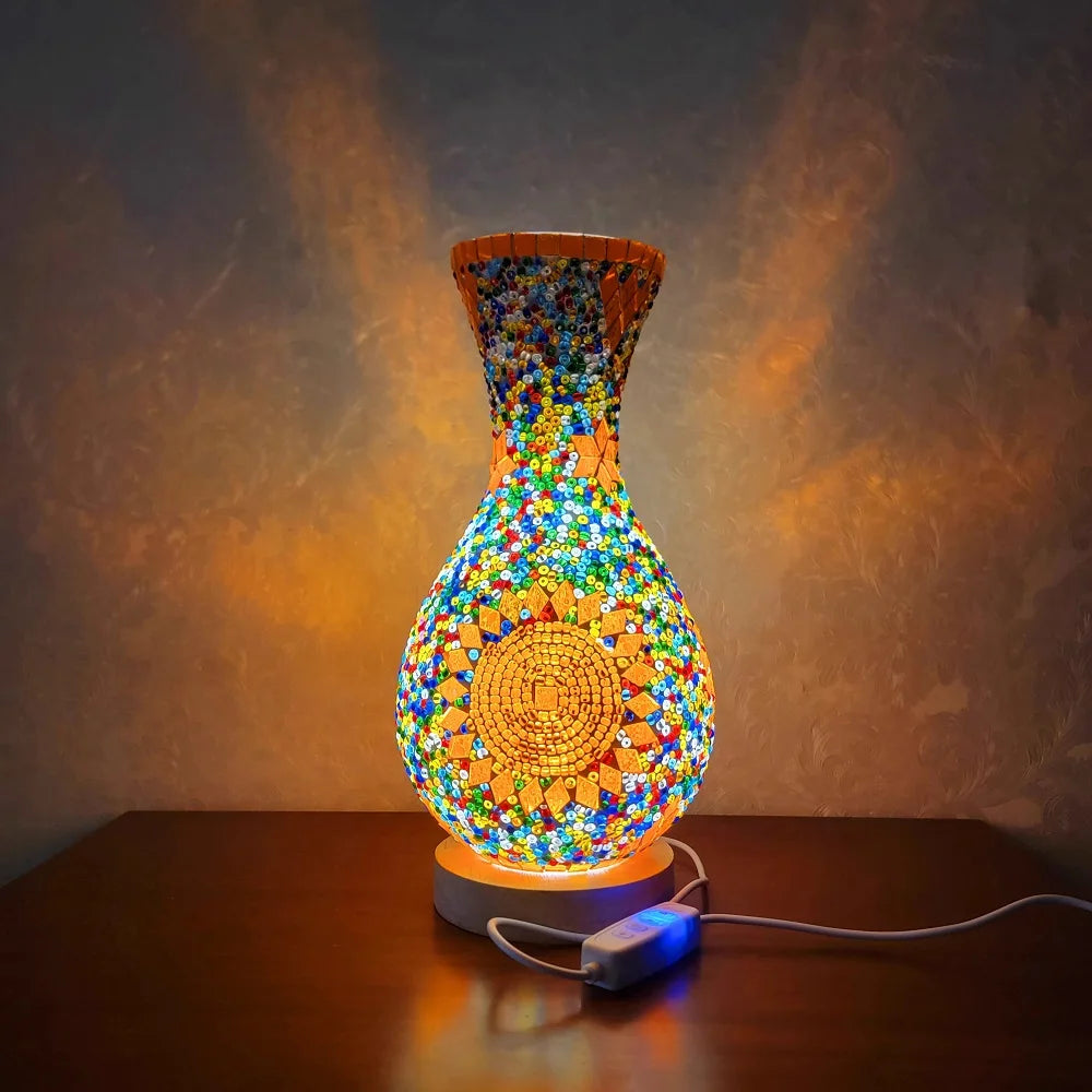 A handcrafted Turkish mosaic table lamp with a warm LED glow, featuring colorful glass pieces in a vase shape.