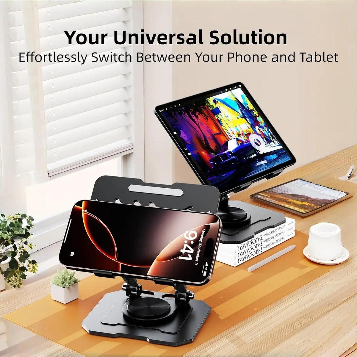 A black 360° rotating carbon steel tablet stand holding an iPhone and a tablet on a wooden desk.