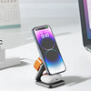 A foldable magnetic charging station is shown with an iPhone, Apple Watch, and AirPods placed on it next to a laptop.