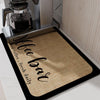 A black mat with the words 'Coffee Bar' embroidered in black script, placed under a coffee maker.