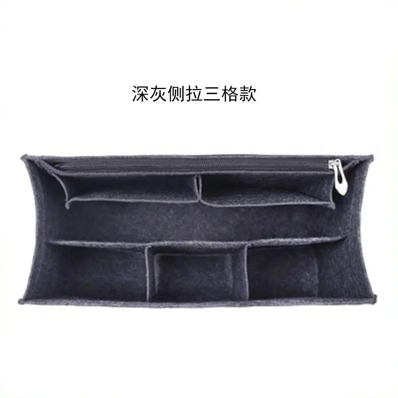 A dark gray felt bag organizer insert featuring multiple compartments and a zipper pocket.