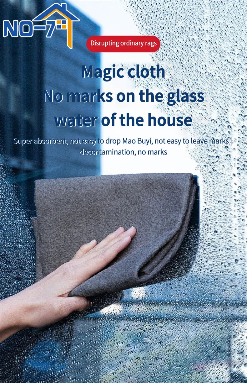 A hand is wiping a window with a gray microfiber cloth, demonstrating its ability to clean glass without leaving marks.