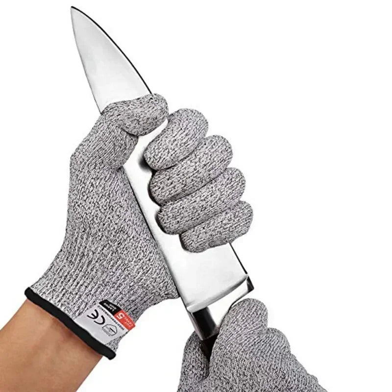 A hand wearing gray cut-resistant work gloves is holding a shiny silver knife.