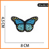 A butterfly embroidered iron-on patch featuring blue and yellow details.