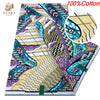A close-up view of a pink glitter African wax print fabric featuring purple, teal, and gold patterns.
