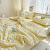 A fluffy yellow breathable summer seersucker quilt draped on a bed with white bedding and natural light.