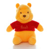 A yellow Winnie the Pooh plush toy bear with a red shirt sitting on a white background.