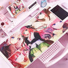 A pink and purple anime themed mouse pad featuring characters, displayed on a desk mat.