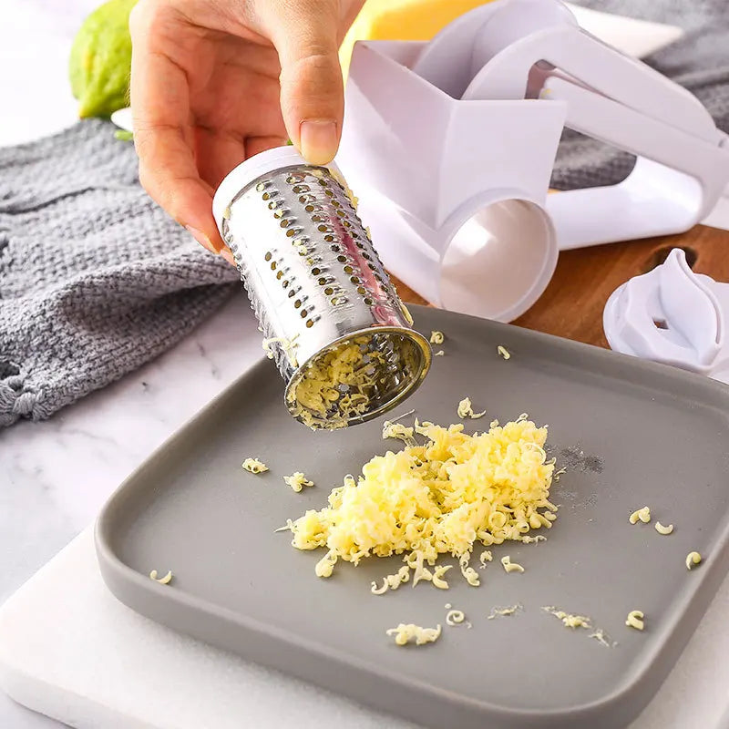 Une main utilise une râpe à fromage manivelle pour râper du fromage sur une assiette grise.