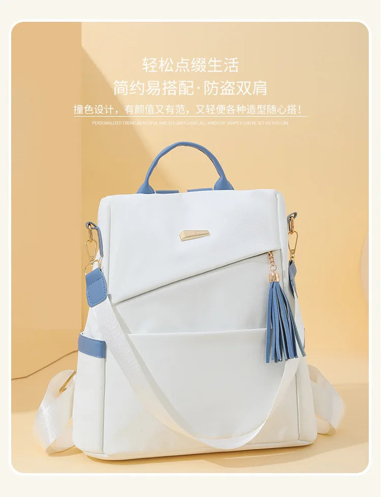 A white women's anti-theft vegan leather backpack with a laptop compartment and blue accents.