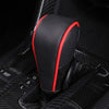 A close-up view of a black and red gear shift knob cover with a perforated texture resting on a black vehicle interior.