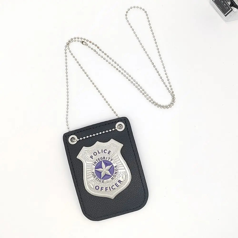 A dark gray police badge accessory featuring a silver shield and star emblem, attached to a chain and clip.