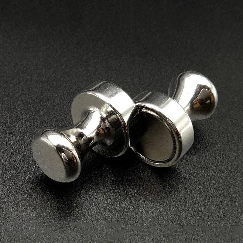 A close-up shot of silver neodymium magnetic pushpins, showing their round heads and shaft.