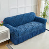 A deep blue jacquard sofa cover with a zebra stripe pattern and an elastic ruffle skirt displayed on a light-colored floor.