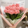 A bouquet of pink chenille craft stems shaped like tulips with a handwritten message