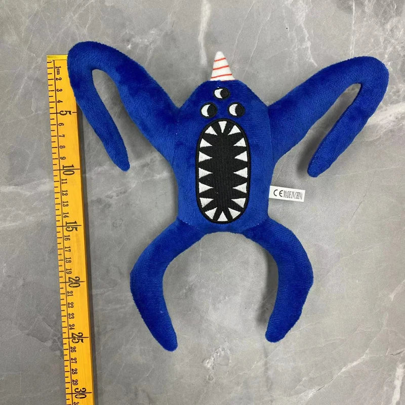 A dark blue plush toy shaped like a bird with a conical white crest and a large, toothy mouth.