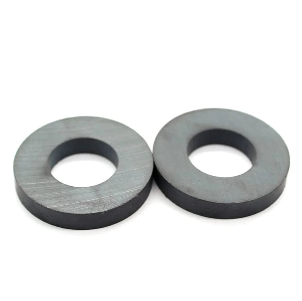 Two industrial-grade ceramic ring magnets with a dark gray finish.