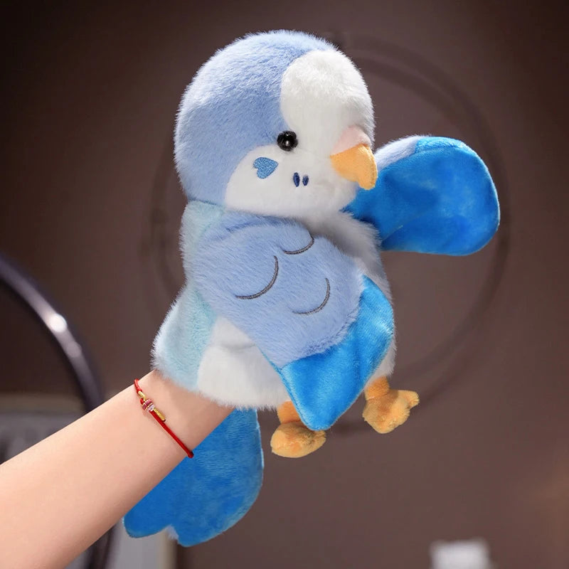 A fluffy blue and white plush parrot hand puppet toy being held by a person's hand.