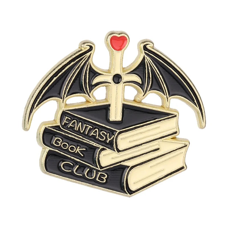 A gold enamel pin featuring a bat emblem with a cross and the words Fantasy Book Club on a black book background.