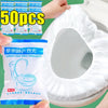 A package of 50 pieces of waterproof disposable toilet seat cover mats next to a white toilet bowl.