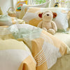 A set of yellow and white cotton duvet covers and pillow shams featuring a teddy bear design.