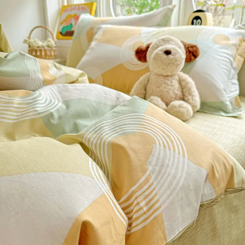 A set of yellow and white cotton duvet covers and pillow shams featuring a teddy bear design.