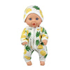 A baby doll wearing a white outfit patterned with yellow and green pineapple motifs.