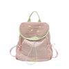 A light pink nylon messenger bag with a green trim and yellow embroidered design.