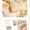 A set of pure cotton bedding including a duvet cover, fitted sheet, and pillowcases in a soft peach floral pattern.