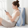 A woman is using a memory foam full-body support pillow while relaxing indoors.