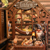 A wooden book nook kit featuring a witch figure and glowing lights set within an arched window frame.
