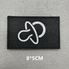 Black fabric patch with a white hook and loop symbol on a gray background