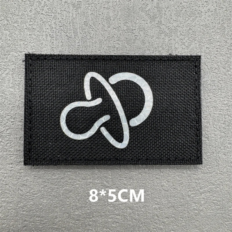 Black fabric patch with a white hook and loop symbol on a gray background