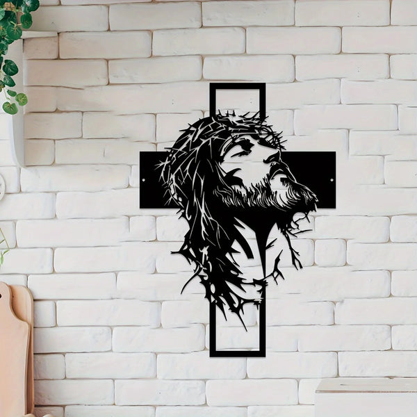 Silhouette de la tête et de la barbe de Jésus en métal noir avec un contour de croix sur un mur de briques blanches