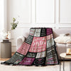 A cozy flannel throw blanket featuring a dark pattern with pink and purple text about sisterhood.