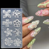 A hand displays various floral silicone nail art molds in translucent gray and pink hues.