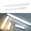 A white motion-activated USB rechargeable LED cabinet light shown in various orientations.