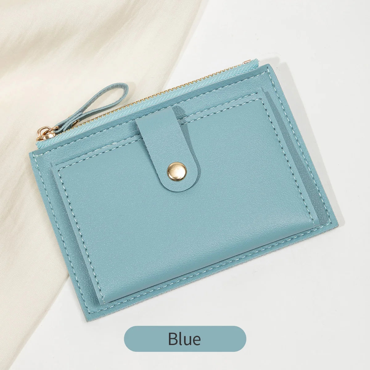A light blue slim PU leather card holder wallet with a gold zipper and silver-toned snap closure.