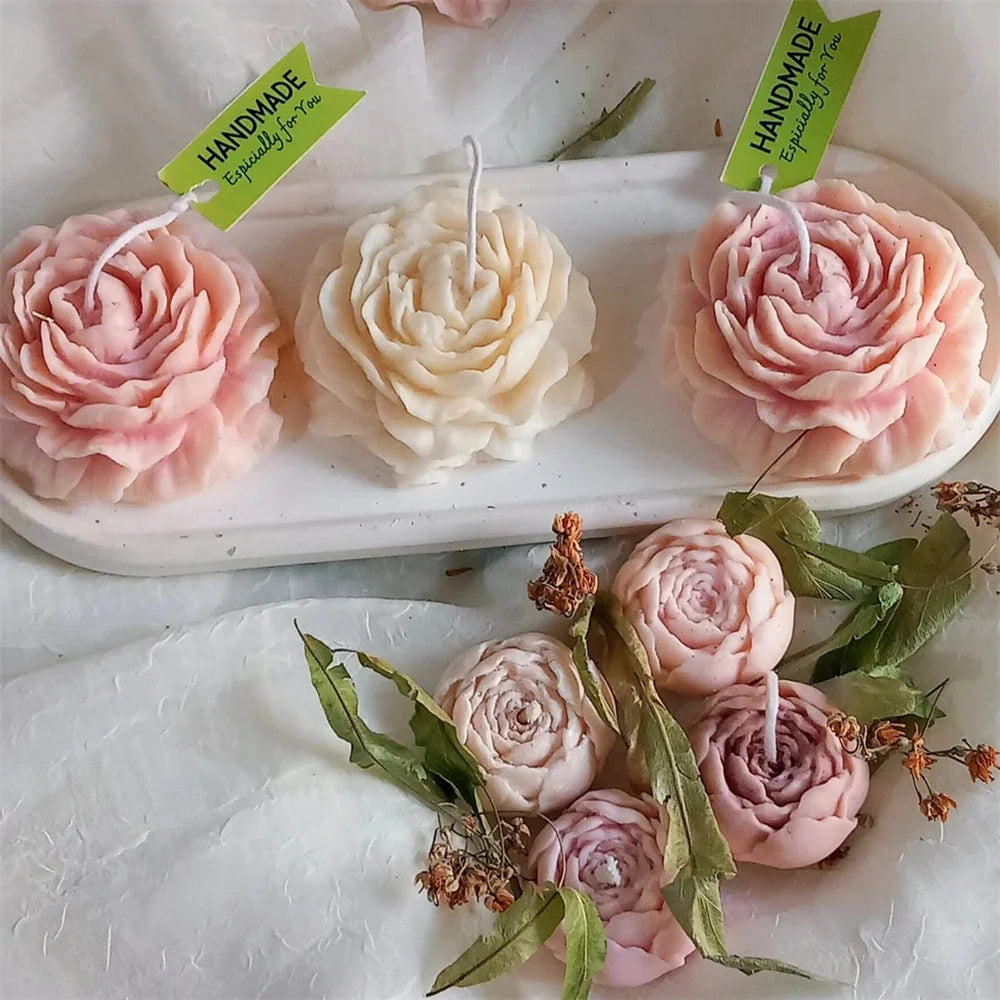 Three handmade pink peony silicone flower molds for candle, resin, and soap making displayed on a white tray.