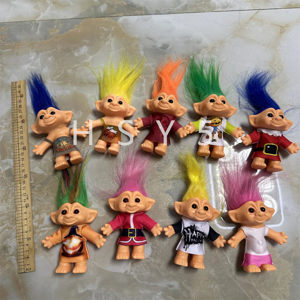 A collection of handcrafted troll doll figurines in various colors and styles displayed on a light surface.