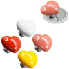 A collection of heart-shaped toilet flush buttons in pink, white, red, and yellow.