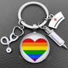 Silver nurse keychain featuring a heart design with the rainbow flag and a medical syringe charm