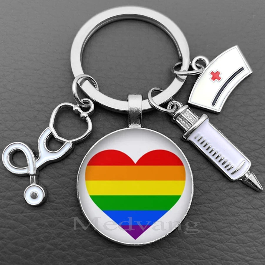 Silver nurse keychain featuring a heart design with the rainbow flag and a medical syringe charm