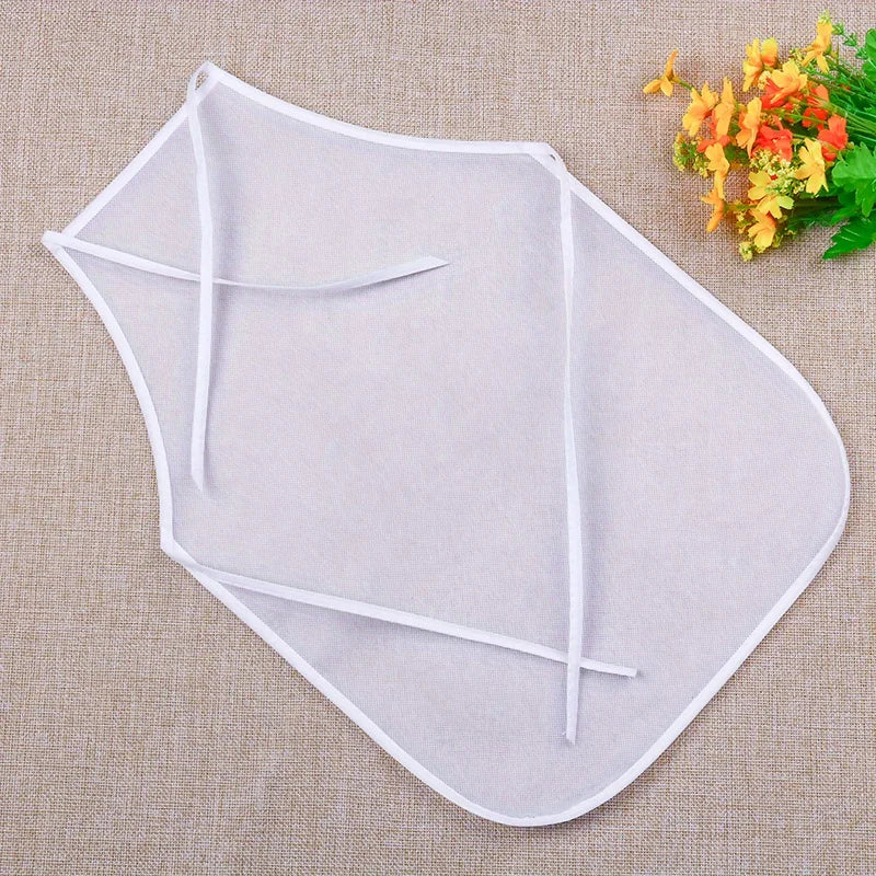 A light gray non-woven fabric craft apron with ties is displayed on a beige background.