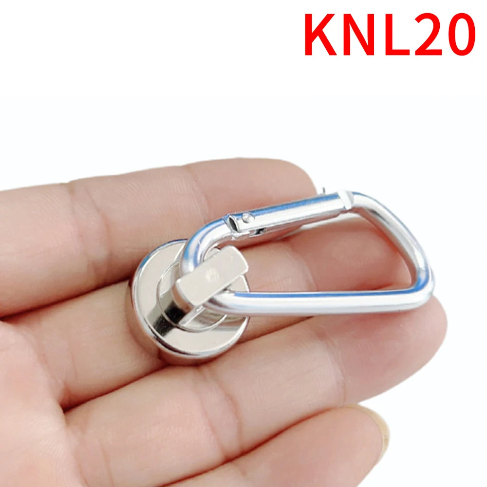 A hand holds a silver heavy duty neodymium magnetic hook with a swivel carabiner.