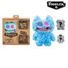 A blue Fuggler ugly monster plush toy with funny teeth and a gray version, packaged in a cardboard box.