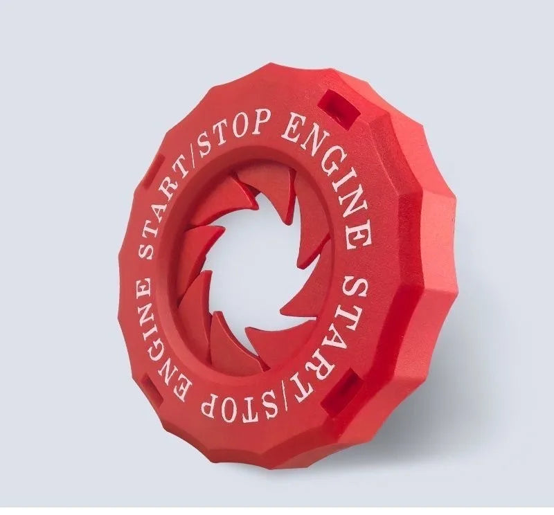A red, hexagonal engine start/stop button cover with a decorative trim.